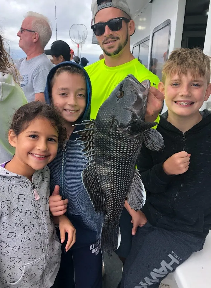 Family with their sea bass catch aboard the Super Hawk on Long Island