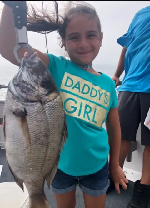 Kid reeling in a fluke